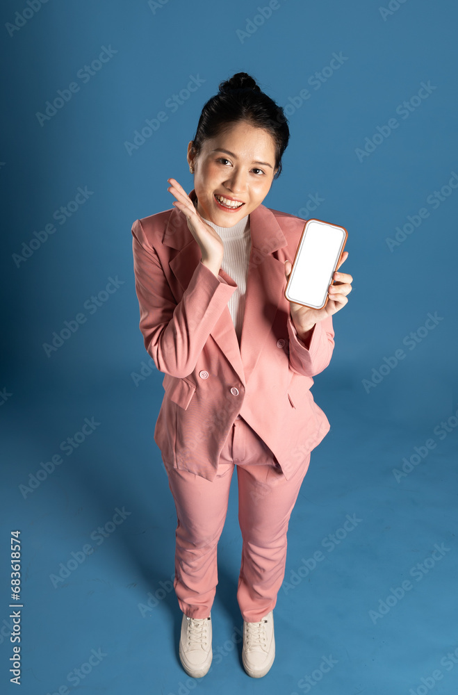 Portrait of young businesswoman standing and posing isolated on blue background Portrait of young businesswoman standing and posing isolated on blue background