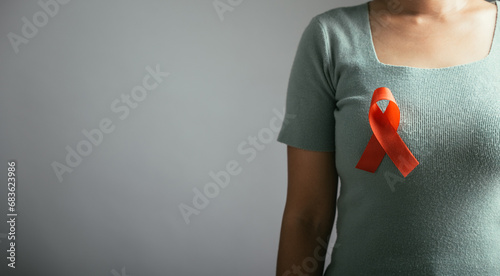 Studio shot of a person proudly wearing an HIV AIDS awareness red ribbon on their chest. Isolated on a white background, symbolizing hope and support for World AIDS Day.
