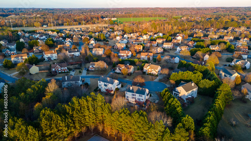 Aerial panoramic view of an upscale subdivision with housing cluster in suburbs of USA shot during golden hour