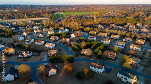 Aerial panoramic view of an upscale subdivision with housing cluster in suburbs of USA shot during golden hour