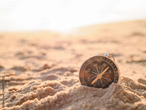 Close up hand holding compass with beach background. The concept of world tourism day, Searching the right directions and Travel