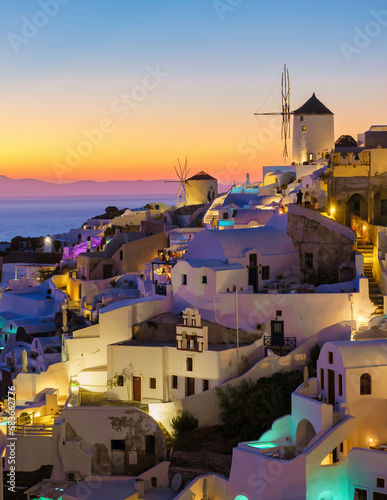 White churches an blue domes by the ocean of Oia Santorini Greece during sunset, a traditional Greek village in Santorini during summer at sunset blue hour