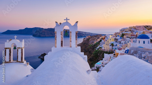 White churches an blue domes by the ocean of Oia Santorini Greece during sunset, a traditional Greek village in Santorini during summer
