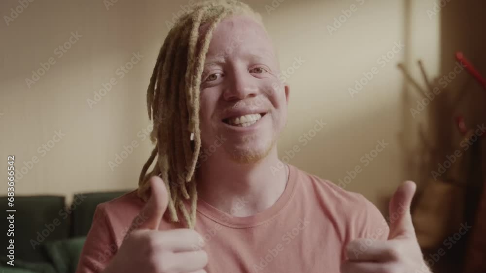 Homem albino sentado na cama dando sinal de positivo. Cinematico 4k. Homem albino sentado na cama dando sinal de positivo. Cinematico 4k.