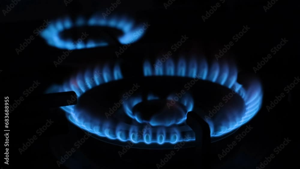 A blue flame burns on the gas stove. Kerosene stove on a black background A blue flame burns on the gas stove. Kerosene stove on a black background