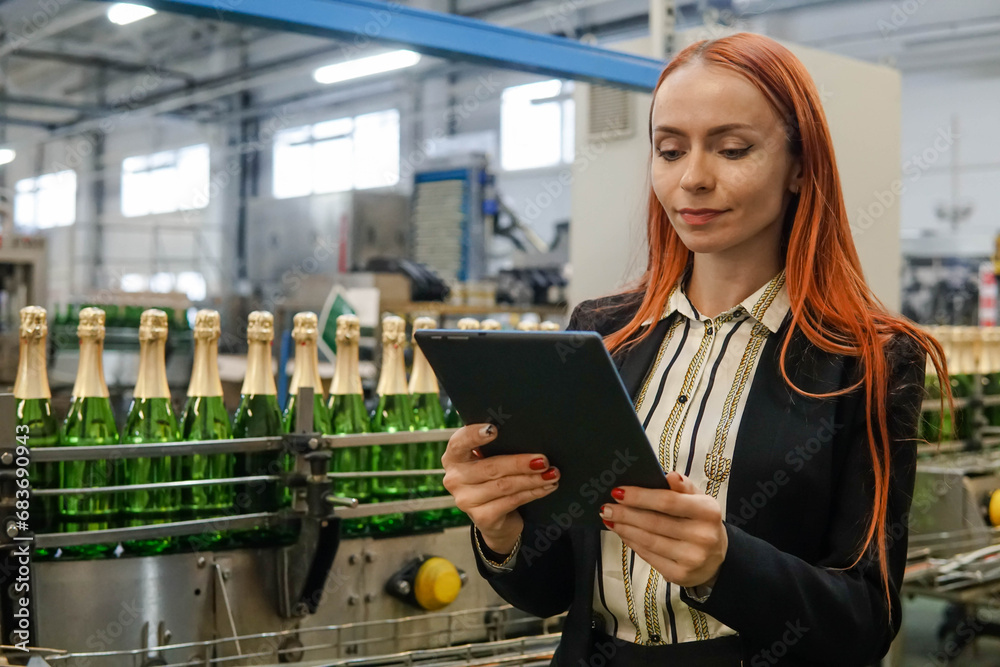 Fototapeta premium Portrait of a Female Engineer Specialist Using Tablet Computer at the Factory of Sparkling Wine. Champagne production.