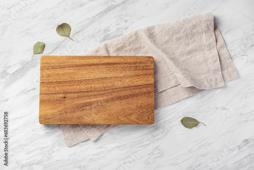 Wood board with linen napkin on marble kitchen countertop photo