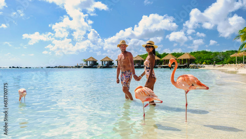 Canvas Print Aruba Beach with pink flamingos at the beach, a couple of men and women on the beach with pink flamingos at Aruba Island Caribbean