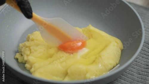 Baker mixing flour, butter, sugar and egg for making choux cream dough