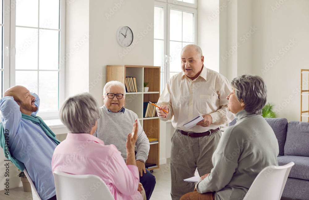 Group of elderly people talking on therapy session at nursing home. Senior men and women sitting in circle and having conversation and discussing some problems together. Psychotherapy concept. Group of elderly people talking on therapy session at nursing home. Senior men and women sitting in circle and having conversation and discussing some problems together. Psychotherapy concept.