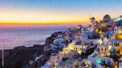 sunset by the ocean of Oia Santorini Greece, a traditional Greek village in Santorini with whitewashed churches and blue domes in the evening blue hour