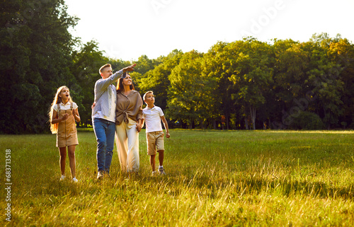 Canvas Print Happy family strolling in park in summer, walking on green grass lawn, enjoying