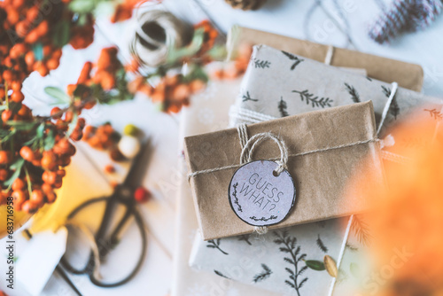 Christmas gift box stack on wooden table with guess what tag photo