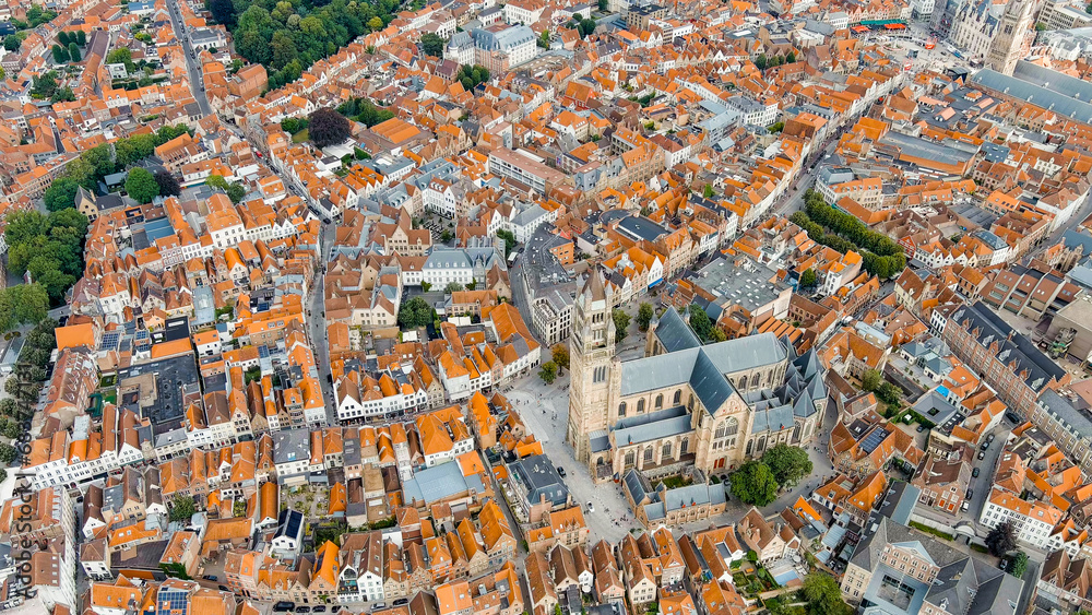Bruges, Belgium. Cathedral of St. Salvator - 14th-century cathedral with a Gothic tower. Panorama of the city center from the air. Cloudy weather, summer day, Aerial View