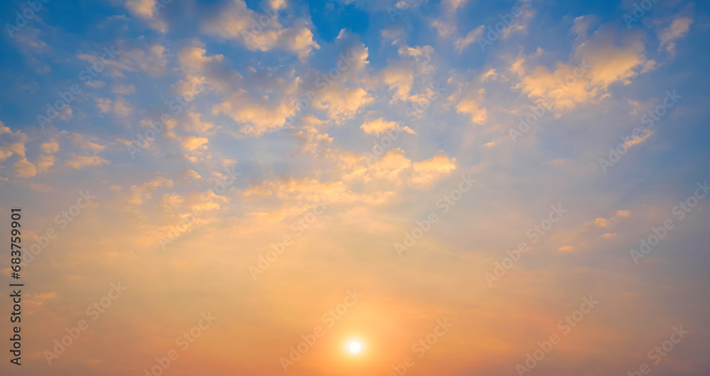 Sunset sky with many golden fluffy clouds and yellow sunlight on horizon sky background in evening time