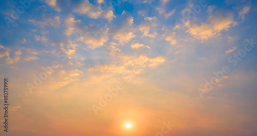 Sunset sky with many golden fluffy clouds and yellow sunlight on horizon sky background in evening time