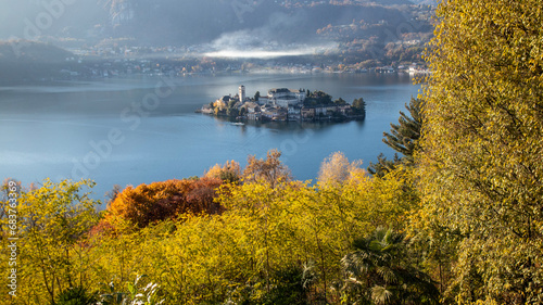 The world famous Orta San Giulio island, in the Orta Lake (piedmont, Northern Italy) seen from the top of Sacro Monte di Orta. UNESCO World Heritage Site, it is home to a convent of cloistered nuns © Stemoir