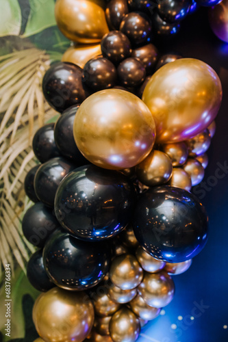 Background, texture of round black, golden, colored balloons on the photo zone against the background of the wall. Photography, holiday, birthday, wedding.