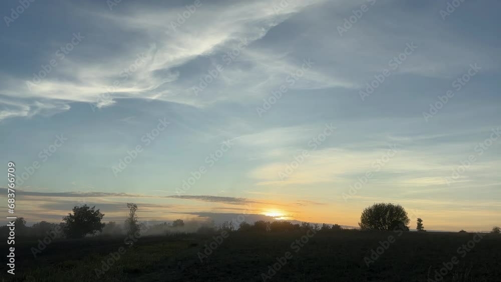 Farmland with tractor cultivating soil against sky at sunset Farmland with tractor cultivating soil against sky at sunset