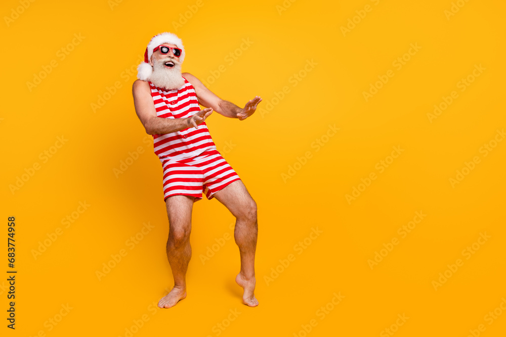 Full length photo of cool cheerful elderly guy wear new year swimsuit hat sunglass having disco fun empty space isolated yellow color background