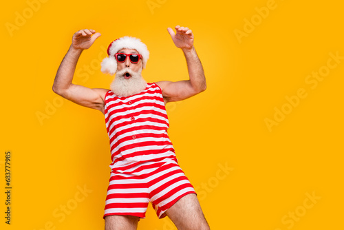Photo of cool cheerful elderly guy wear new year swimsuit hat sunglass enjoying disco empty space isolated yellow color background © deagreez