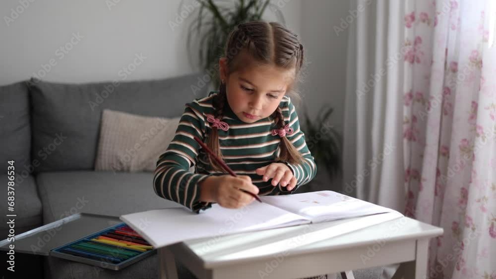 Portrait of happy little girl drawing at home. Girl with beautiful hairstyle using pencils. Five year old kid Portrait of happy little girl drawing at home. Girl with beautiful hairstyle using pencils. Five year old kid