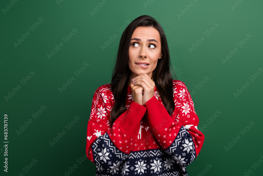 Portrait of nervous minded girl biting lips look interested empty space brainstorming isolated on green color background Portrait of nervous minded girl biting lips look interested empty space brainstorming isolated on green color background