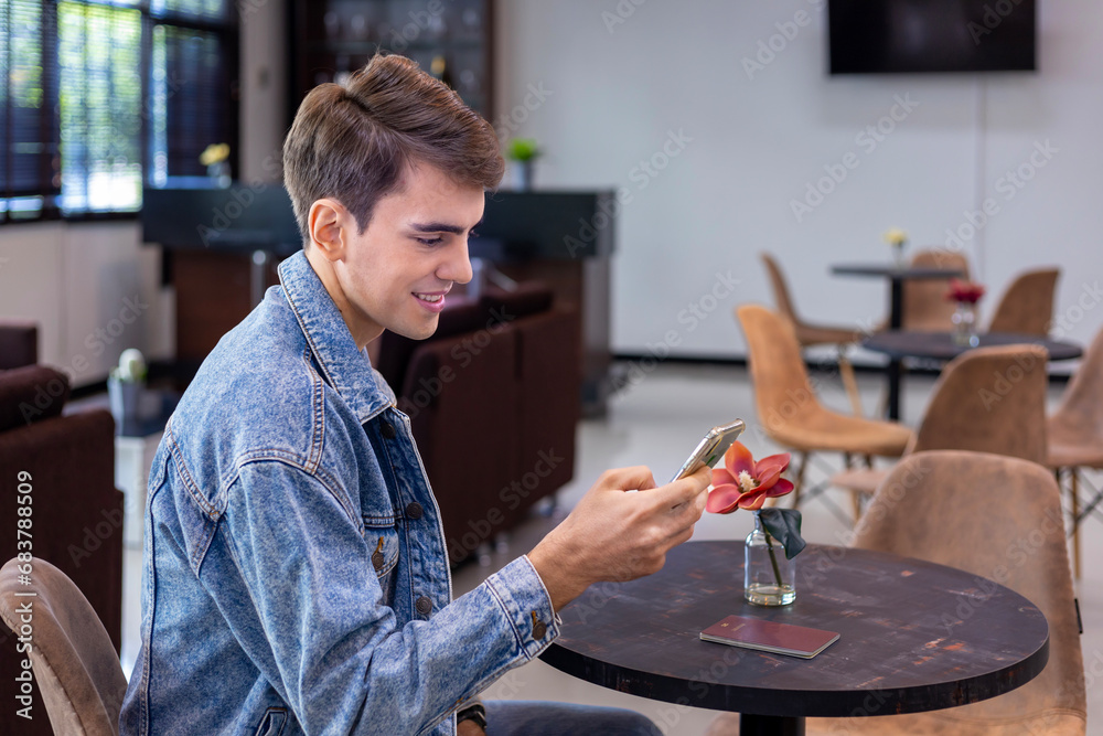 Caucasian traveller is using mobile phone for video call while waiting in airline business departure lounge waiting for boarding airplane