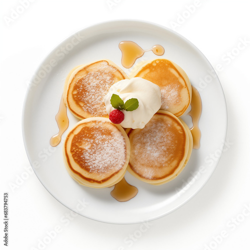 3 small thick pancakes with sour cream on a white ceramic plate