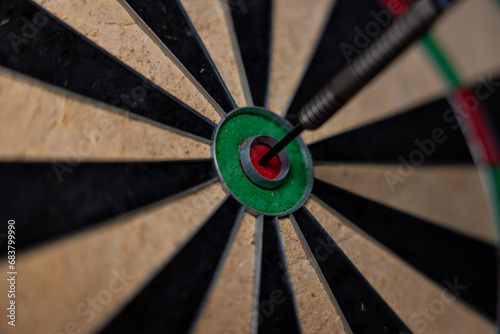 A dart arrow stick on the center of dart board. Bulls eye. Business goal concept.