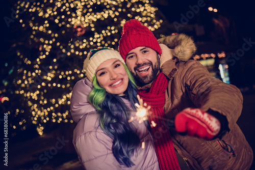 Portrait of lovely peaceful partners arm hold bengal lights stick magic christmastime fairy capital center tree garland outside
