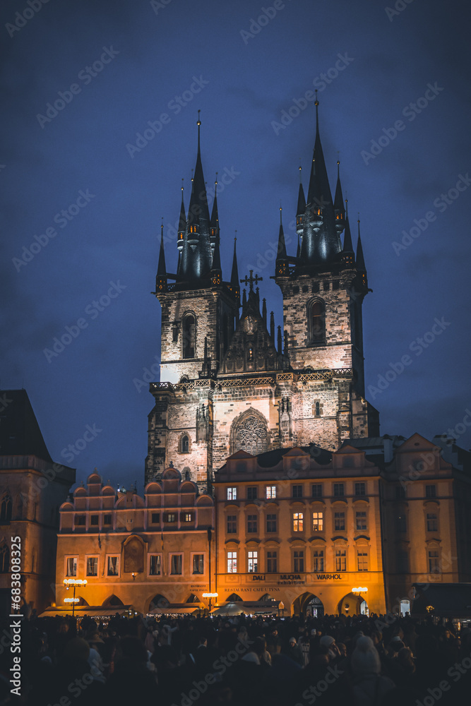Castle in Prague during the night with a crowd in front of it. 
