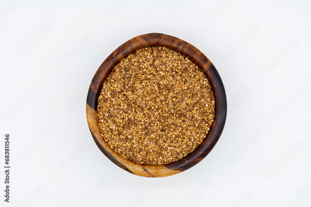 Sesame seeds on a wooden plate isolated on a white background
Sesame seeds on a wooden plate isolated on a white background