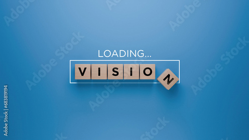 Wooden blocks spelling 'VISION' with a loading progress bar on a blue background, strategic planning and foresight concept
