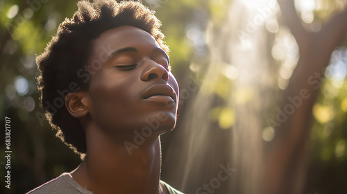 Headshot of a young African man breathing fresh air in a hazy park under the morning sun