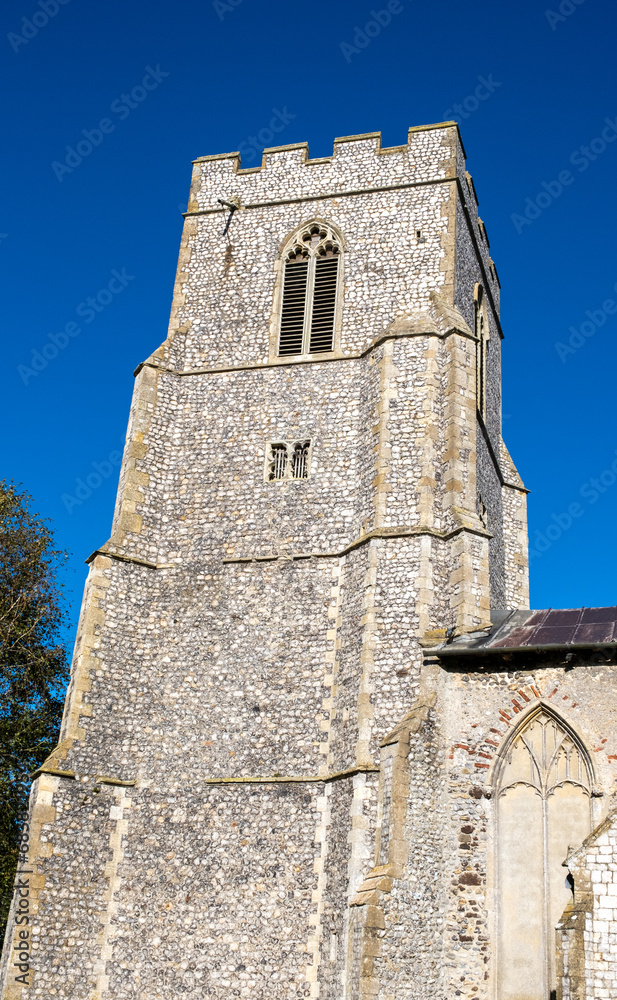 Exterior of a rural catholic church tower in sunlight