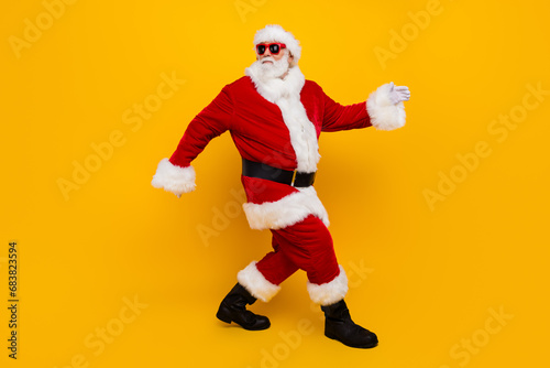 Full body profile photo of charismatic aged santa walking empty space christmas ad isolated on yellow color background
