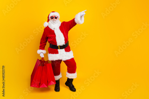 Full length photo of advert poster happy new year season sale with saint nicholas point finger mockup isolated on yellow color background