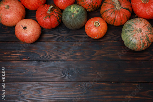 Thanksgiving colorful pumpkins on dark rustic wooden table background. Fall menu, October, November holiday, harvest season. Top view, festive template  with copy space