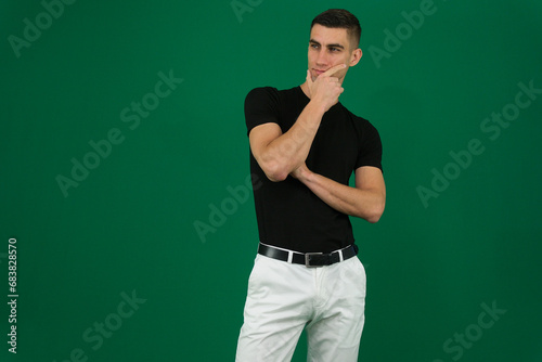 portrait of a young man thinking against a removable chroma key background. High quality photo