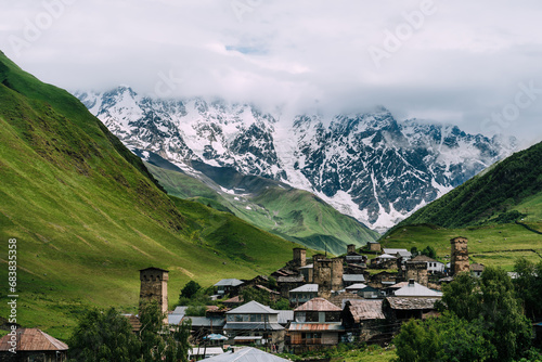 Panoramic view of medieval towers and Shkhara peak in village Ushguli in the Caucasus Mountains, Georgia.Stone towers and ancient houses in Ushguli, Georgia. UNESCO site, popular tourist destination. photo