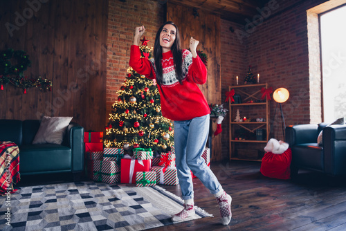 Photo portrait of attractive brunette young woman winning raise fists dressed ornament sweater living room christmas decorations