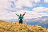 Outdoor portrait of happy young woman hiking in autumn mountains, back view, arms wide open