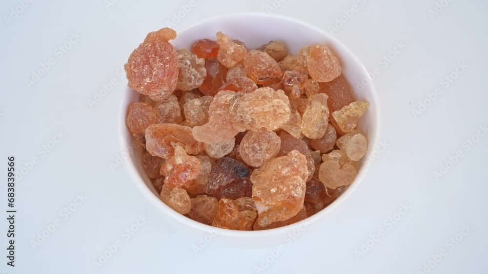 Fresh Gum Arabic falling in a white plate on a white background Fresh Gum Arabic falling in a white plate on a white background