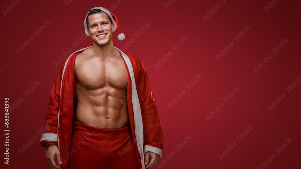 Fototapeta premium Cheerful fitness Santa smiling with a jacket over his shoulder