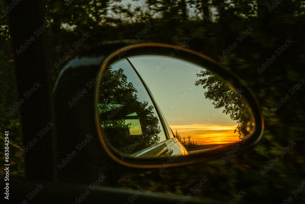 Reflection in car side mirror rural view in countryside 