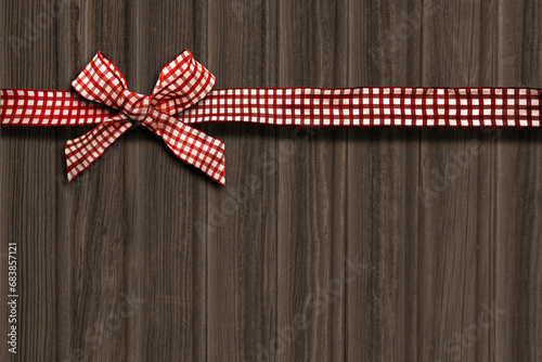 Weihnachtshintergrund aus Holz und mit Geschenkband und Schleife