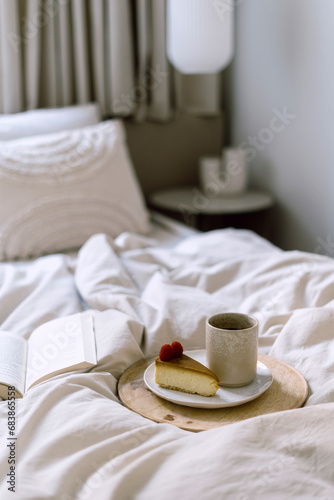 Wooden tray with cup of coffee and cheesecake on rumpled bedding in bedroom © brizmaker