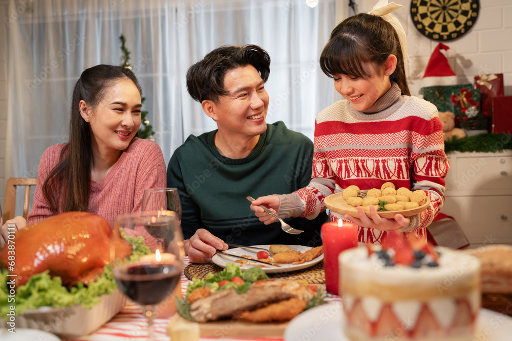 Happy Asian family mother, father and daughter having dinner celebrating Christmas at home Happy Asian family mother, father and daughter having dinner celebrating Christmas at home