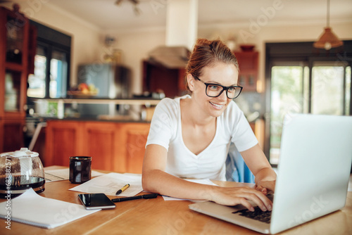 Smiling young woman doing financials at home